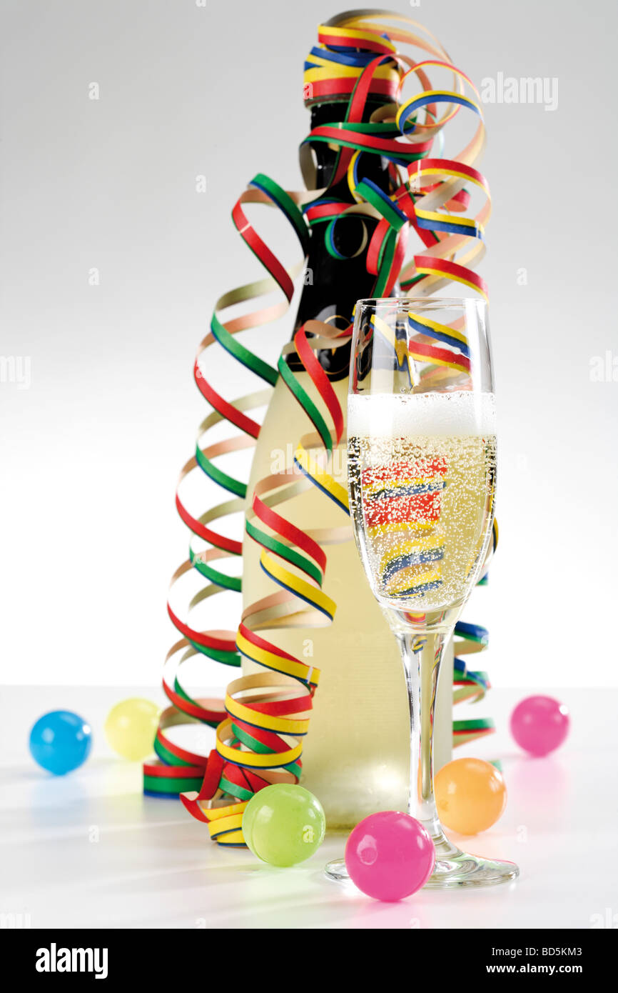 Bottle and glass with champagne, streamers and coloured balls Stock Photo