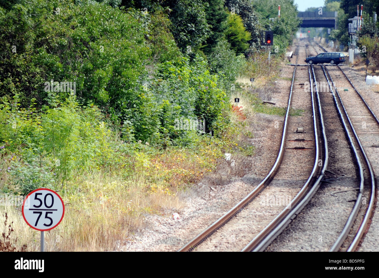 Royalty free photograph of railway tracks with car on the level crossing in London UK Stock Photo