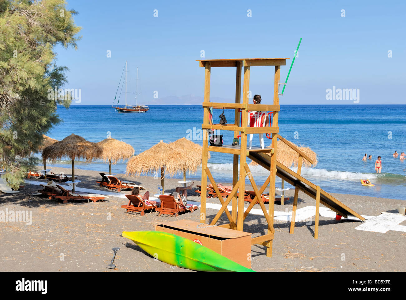 Perissa beach and lifeguard post. Perissa beach consist of black sand, which gets very hot during the sunny day. Perissa, Thira. Stock Photo