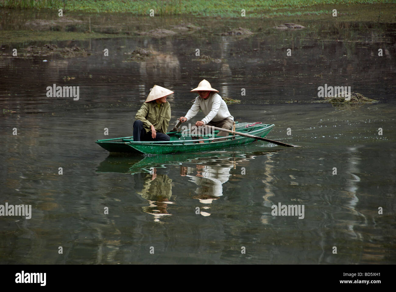 Two Vietnamese in rowing boat Ngo Dong River Tam Coc Ninh Binh Province Northern Vietnam Stock Photo