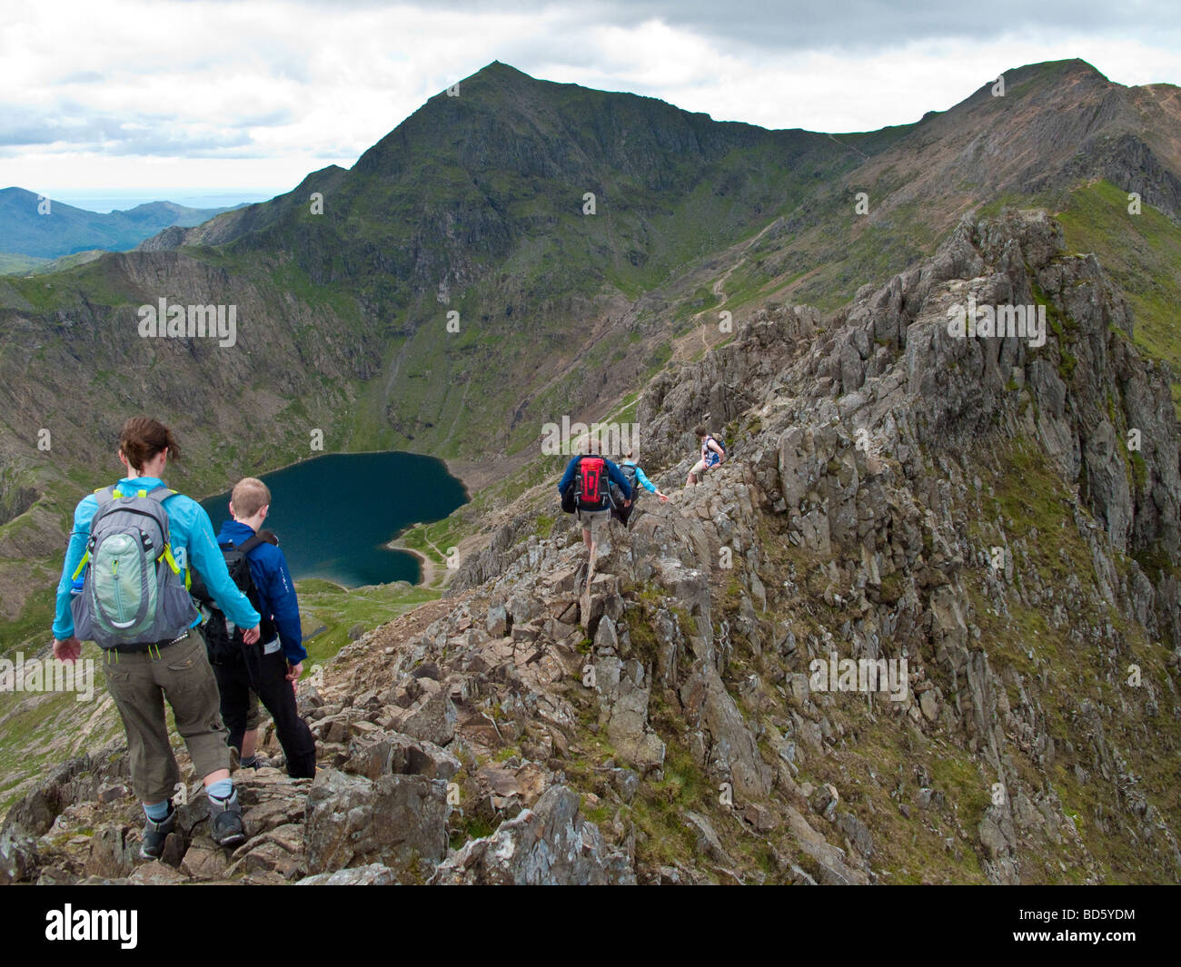 Walking along the knife edge ridge between Crib Goch and Mount Snowdon, North Wales. Stock Photo