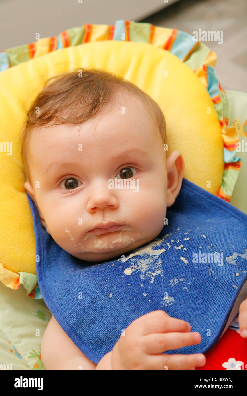 cute baby girl with bib in padded chair Stock Photo Alamy