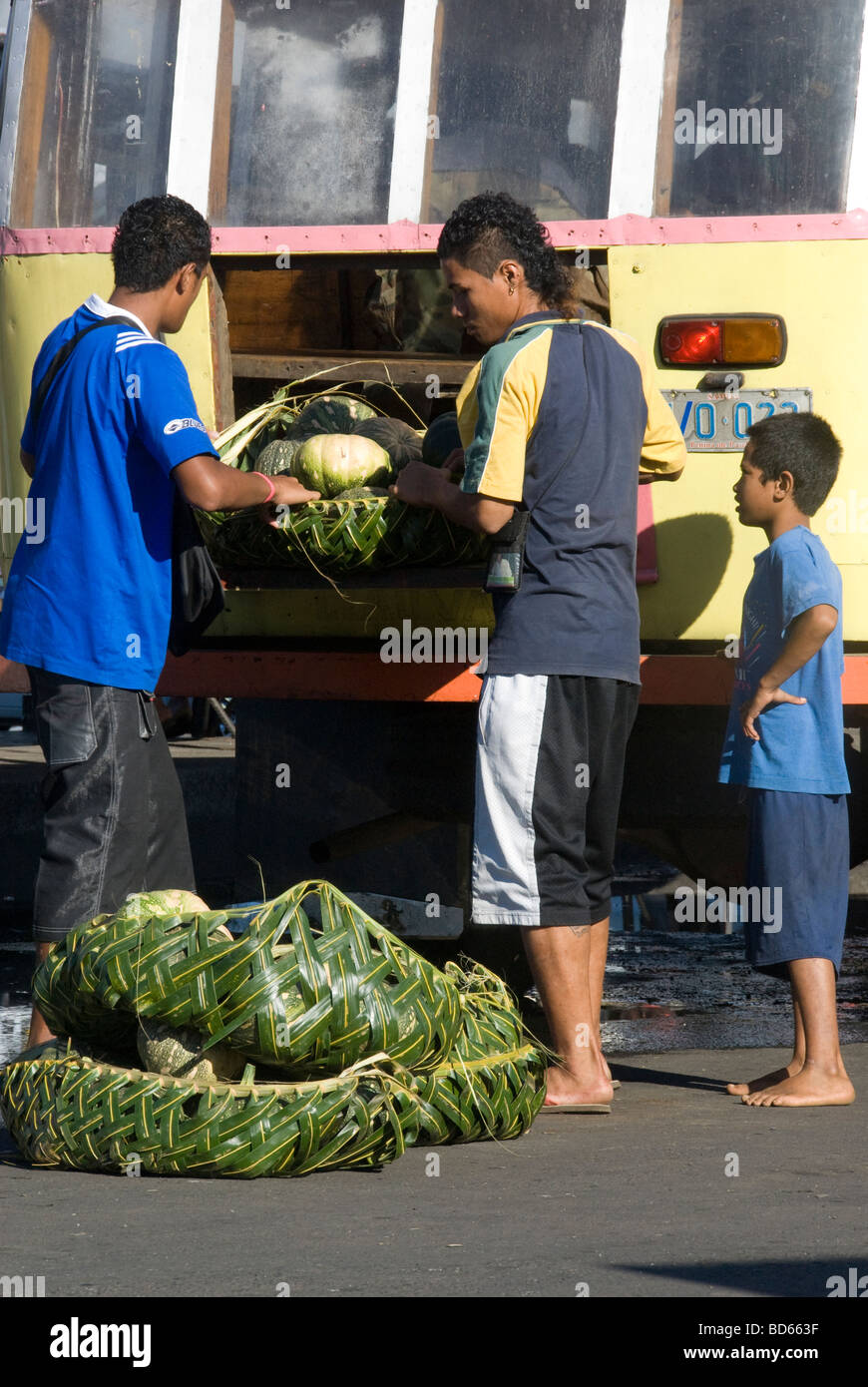 Unloading market produce from brightly coloured bus in Apia, Western Samoa Stock Photo
