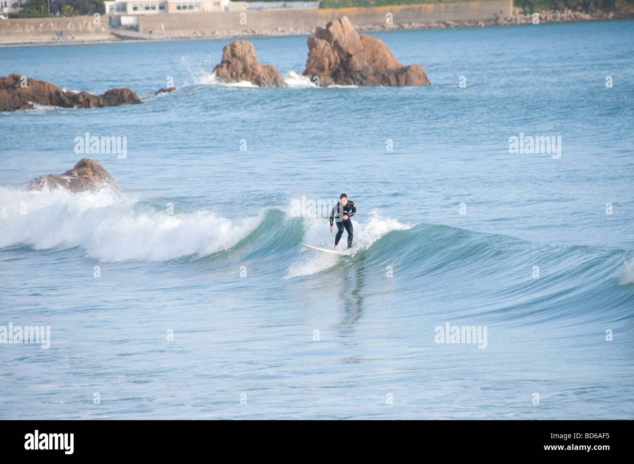 Surfing at St Brelades bay, Jersey, Channel Isles Stock Photo