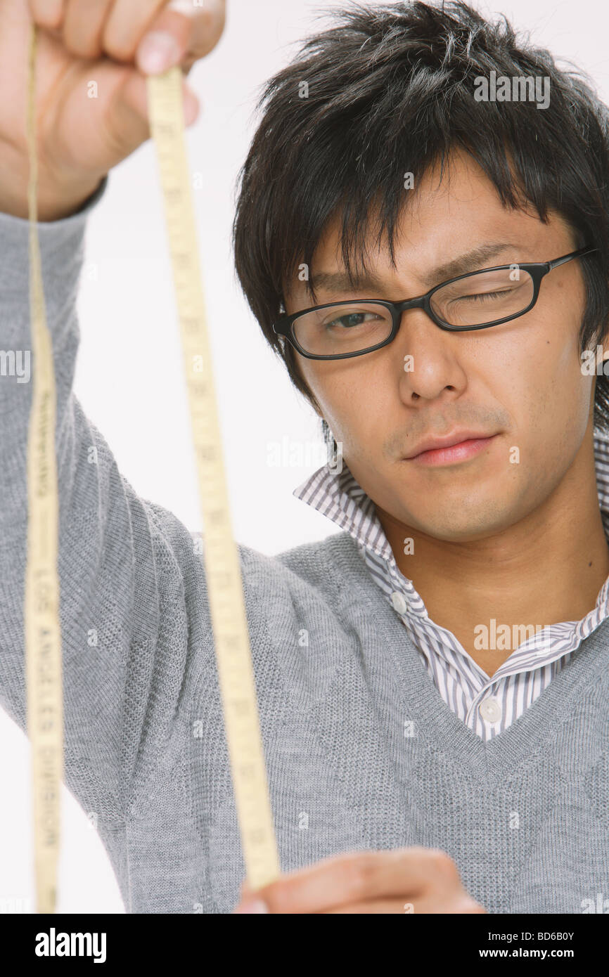 Young man analyzing tape measure Stock Photo Alamy