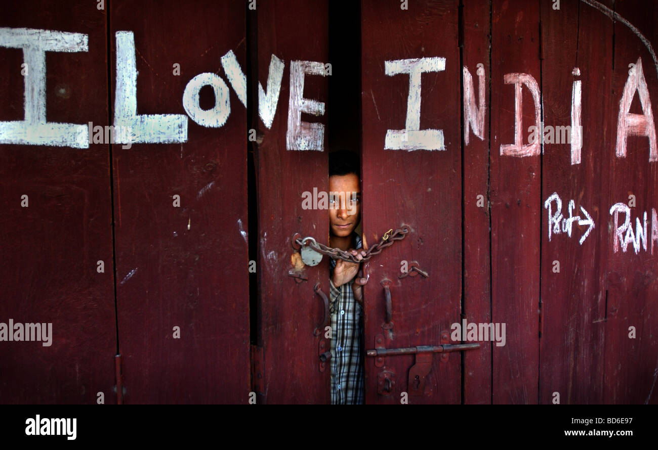 An Indian boy stands inside a shop near Ahknoor in the Indian held state of Jammu and Kashmir May 29 2002 Indian and Pakistani Stock Photo