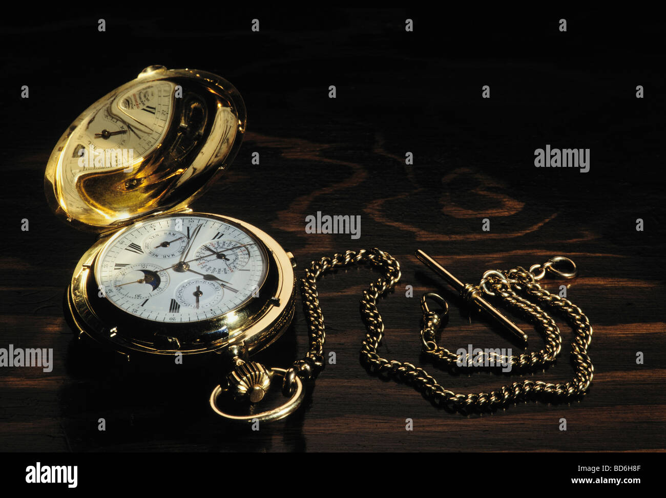 Old gold pocket watch on wooden table Stock Photo - Alamy