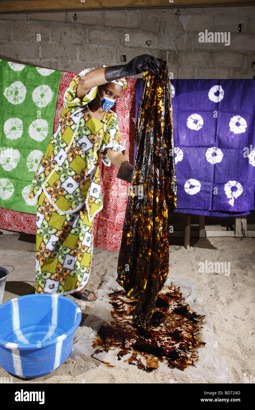 Woman wearing a respirator while batik dyeing fabric, working from home, Maroua, Cameroon, Africa Stock Photo