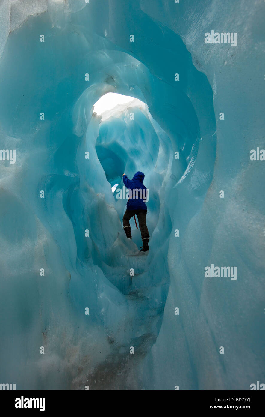 Franz Josef Glacier, New Zealand; hiker in small ice tunnel on Franz Josef Glacier Stock Photo
