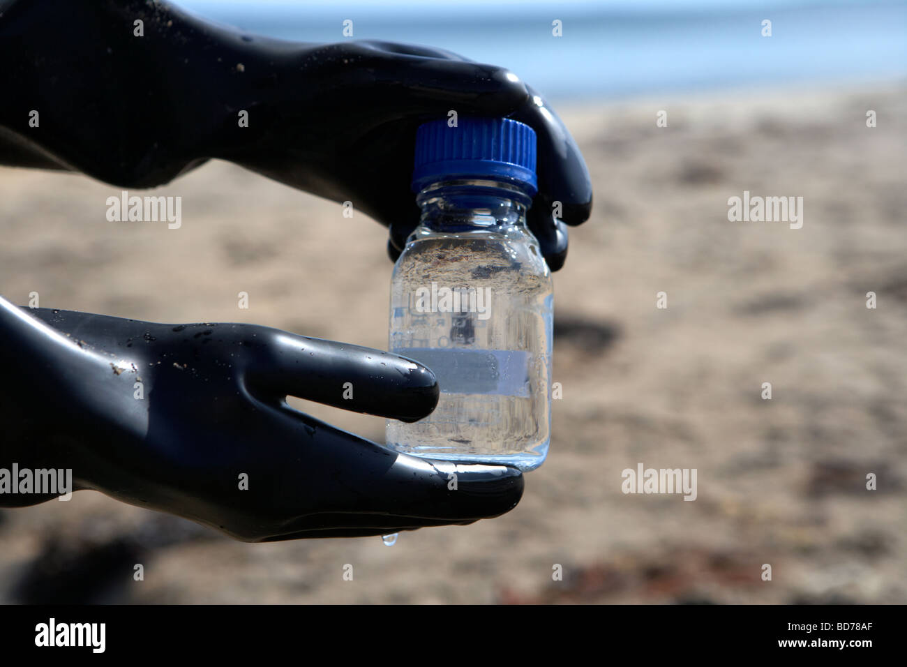 northern ireland environment service operative sampling water from local beach to assess water quality standards in the uk Stock Photo