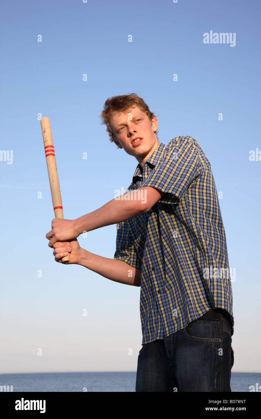 Teenage boy holding a bat ready to hit the ball in a game of rounders. Stock Photo
