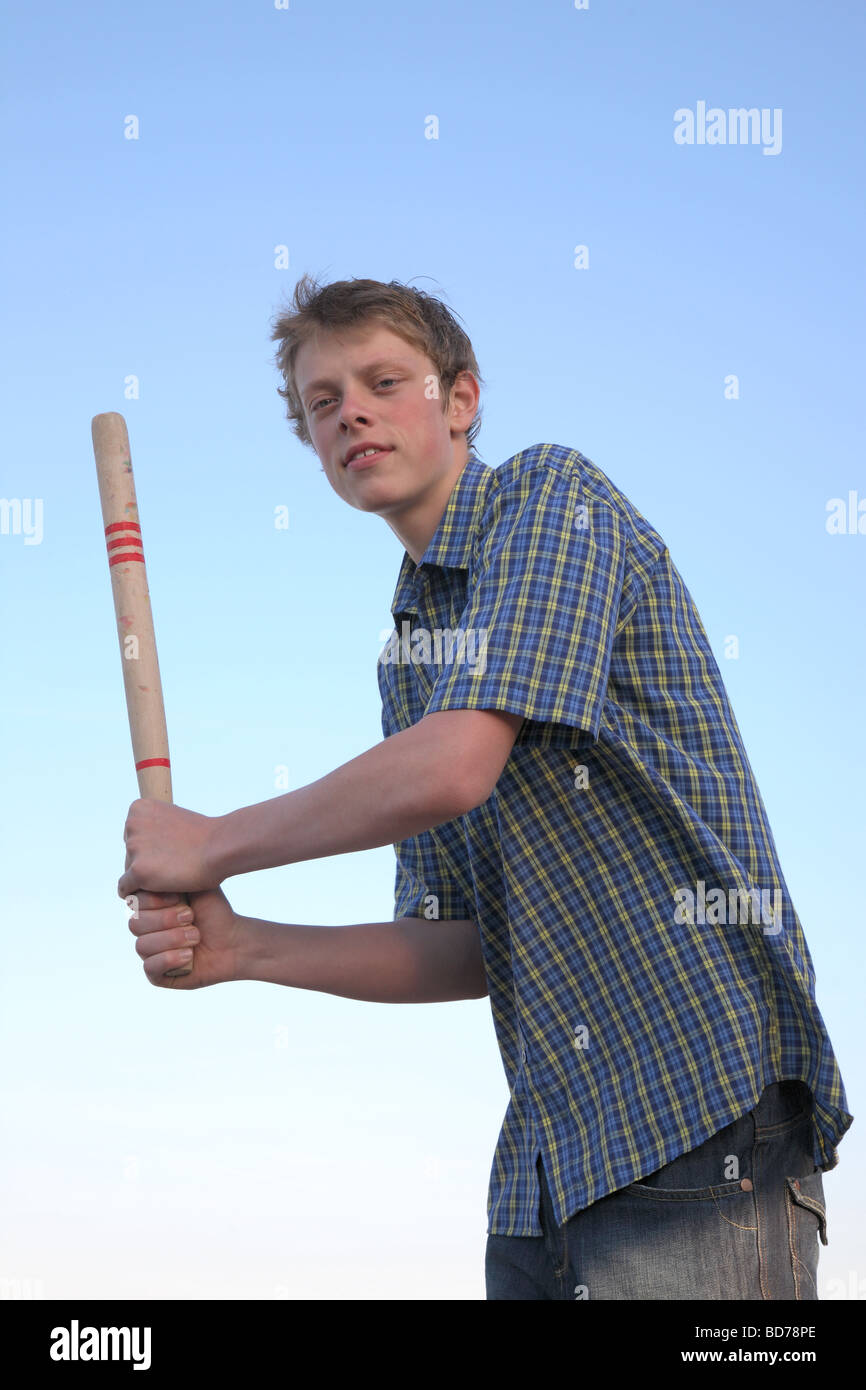 Teenage boy holding a bat ready to hit the ball in a game of rounders. Stock Photo