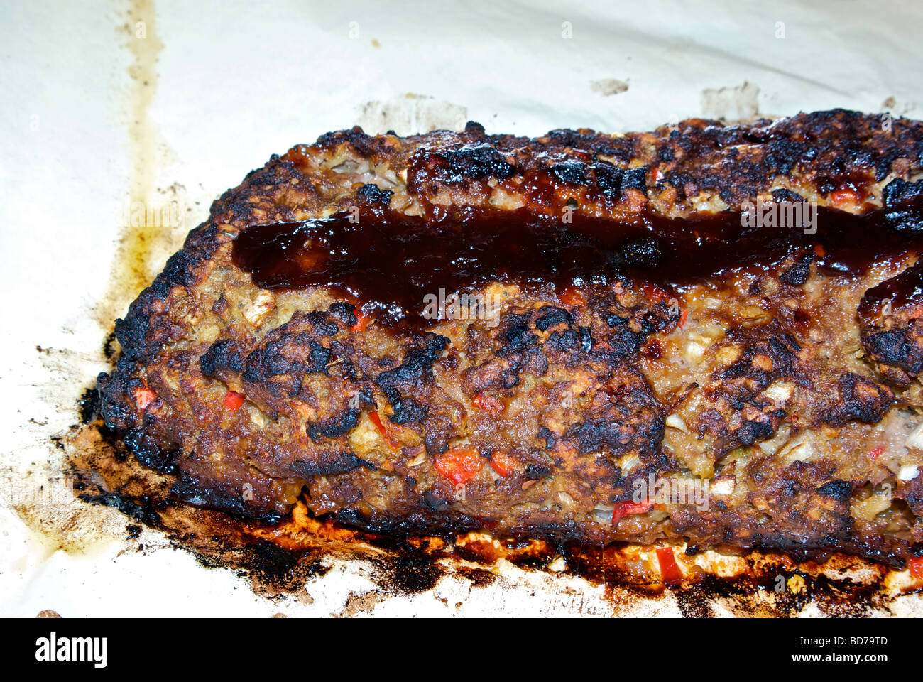 Crusty sweet glazed oven baked meatloaf on parchment paper Stock Photo
