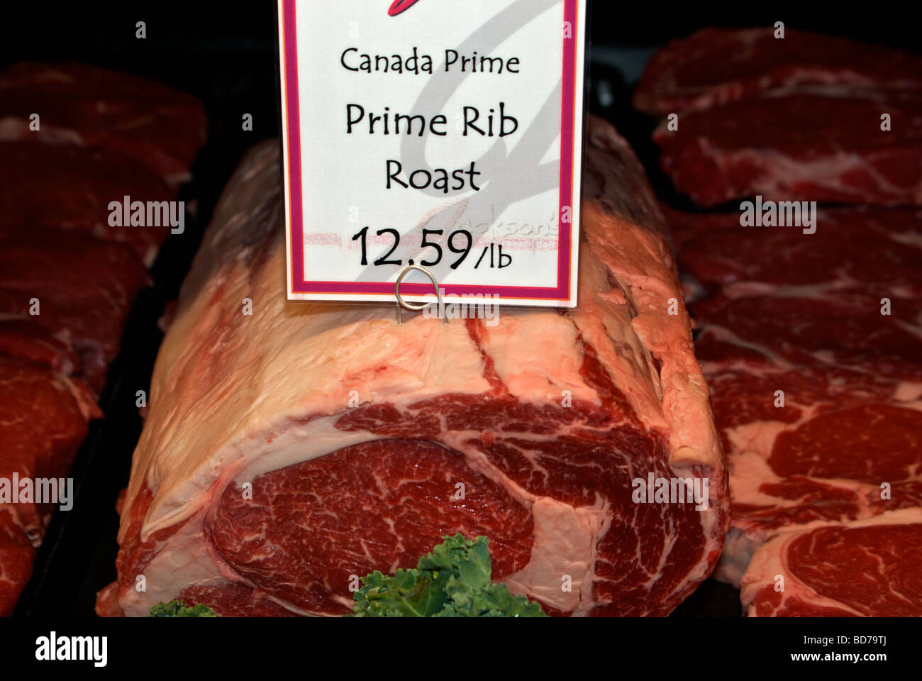 Display cooler case trays of beef prime rib steaks roasts priced Stock Photo