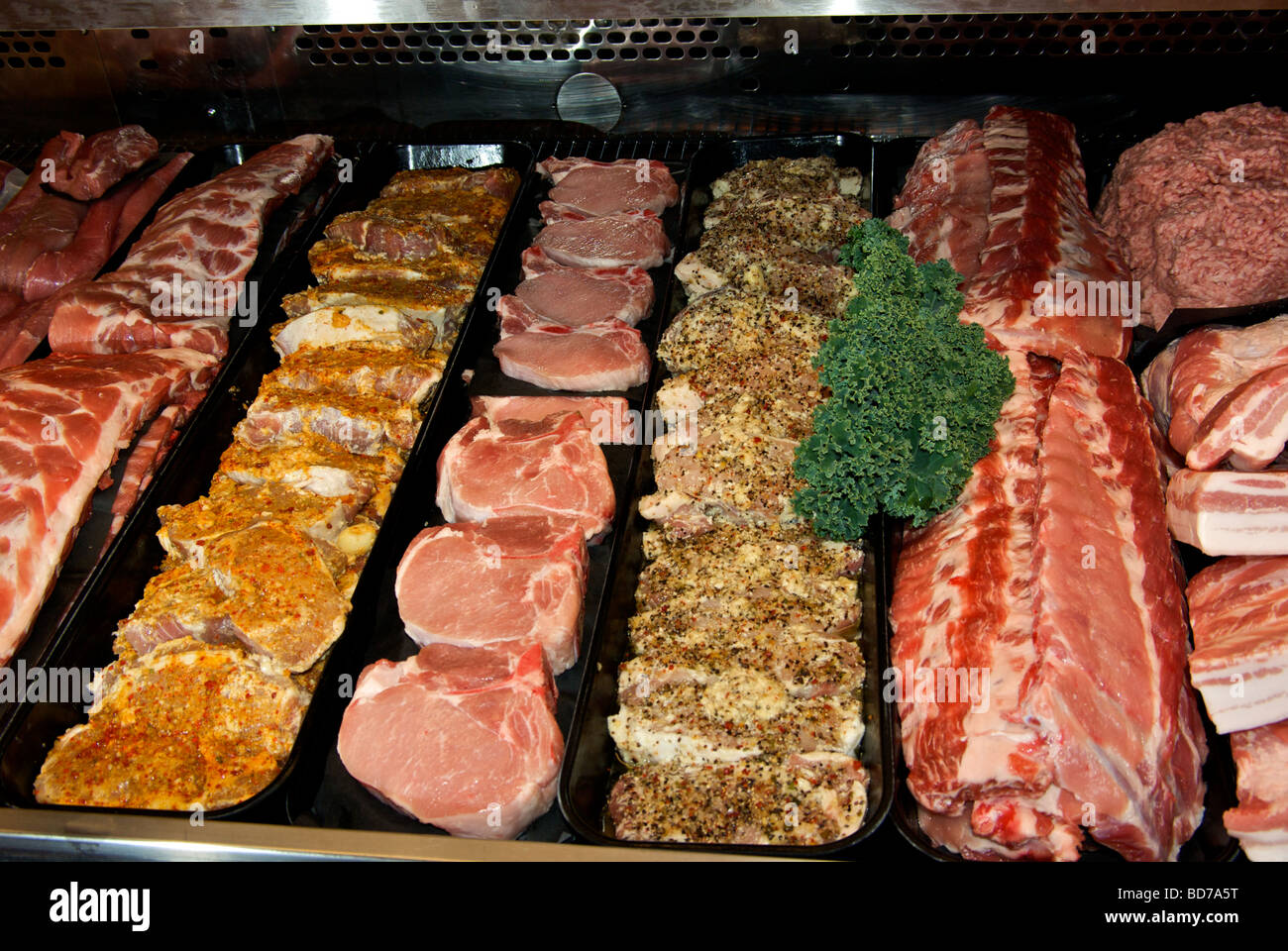 Meat display cooler case with raw uncooked pork products chops roasts