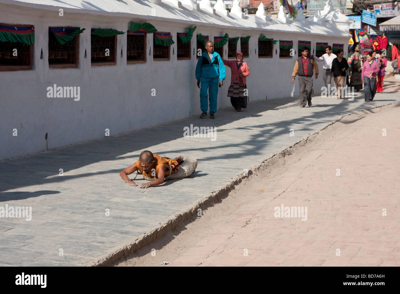 Bodhnath, Nepal.   A Buddhist Devotee Seeks Merit, Blessings and Forgiveness by Circling the Stupa in a series of Prostrations. Stock Photo