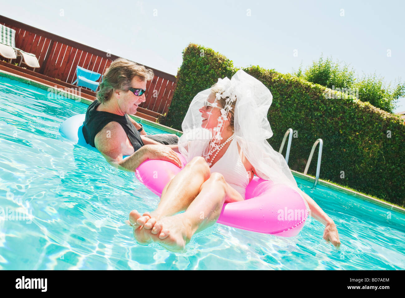 Bride and groom in swimming pool Stock Photo