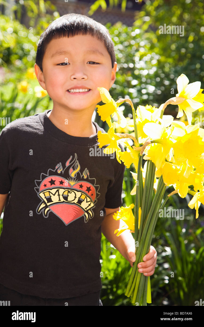 Boy holding daffodils in garden Stock Photo Alamy