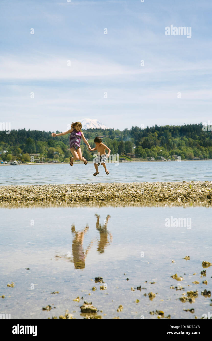 Children jumping on beach Stock Photo