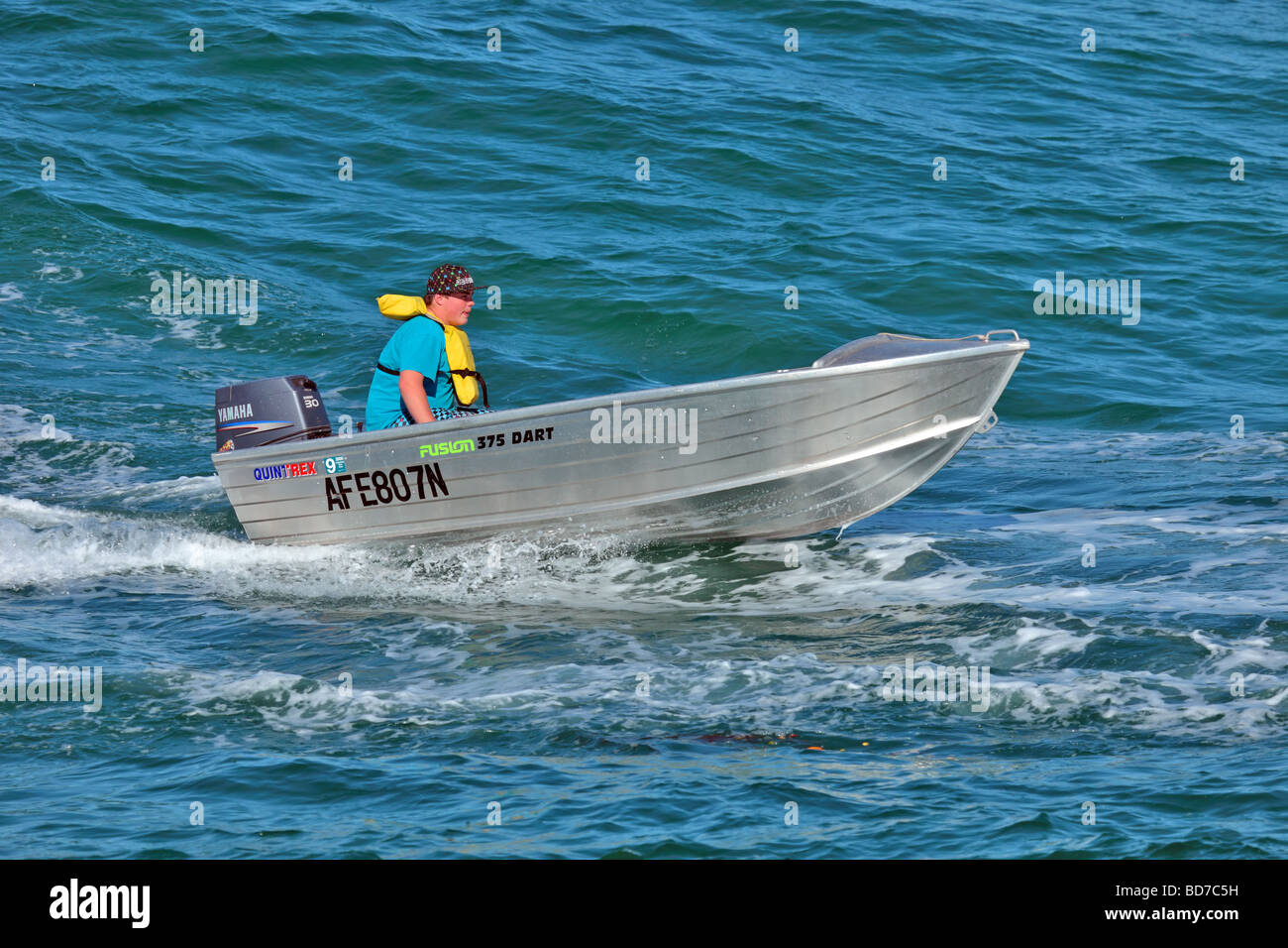 Small dingy or tinny with outboard motor on the water Stock Photo