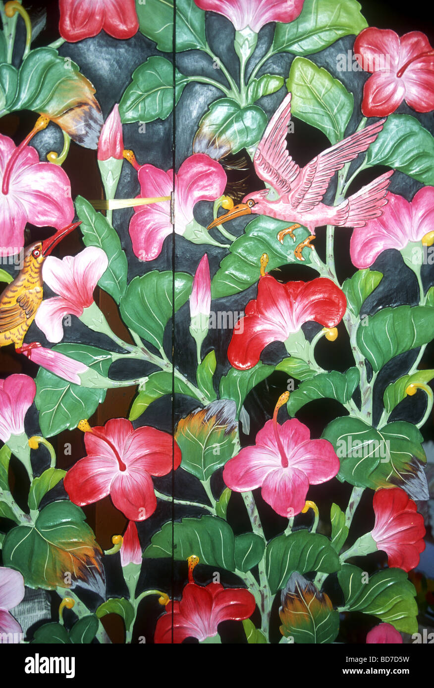 Intricate colorful Balinese wood carving of intertwined Hibiscus flowers,exotic birds  and leaves Stock Photo