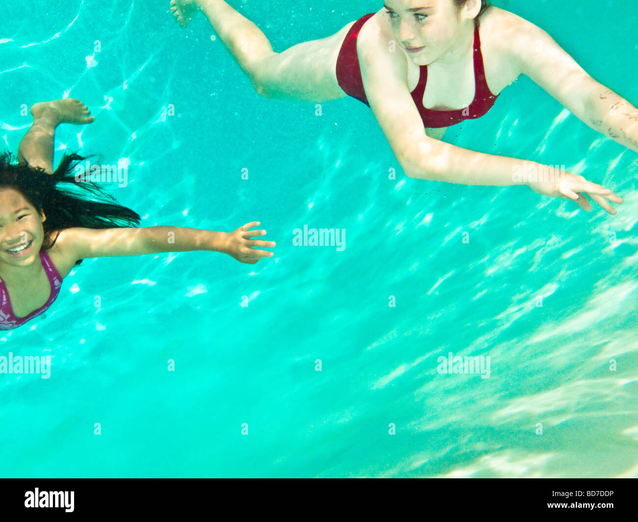 Two girls swimming under water Stock Photo