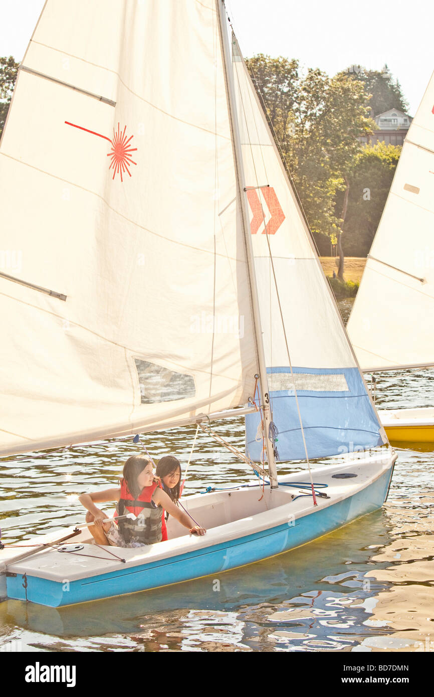Two girls sailing small boat Stock Photo