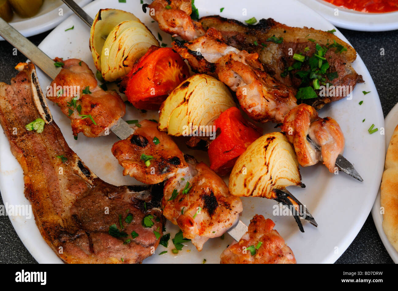 Grilling marinated shashlik preparing on a barbecue grill over charcoal.  Shashlik is a form of Shish kebab popular in Eastern Europe. Shashlyk (meaning  skewered meat) was originally made of lamb. Stock Photo