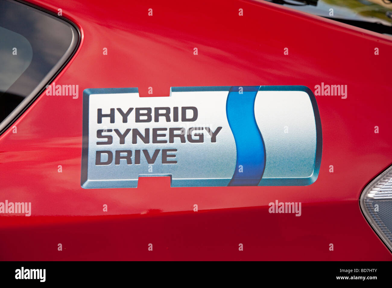 Hybrid Synergy logo on door of red Toyota Prius T3 hybrid car parked Cheltenham UK Stock Photo