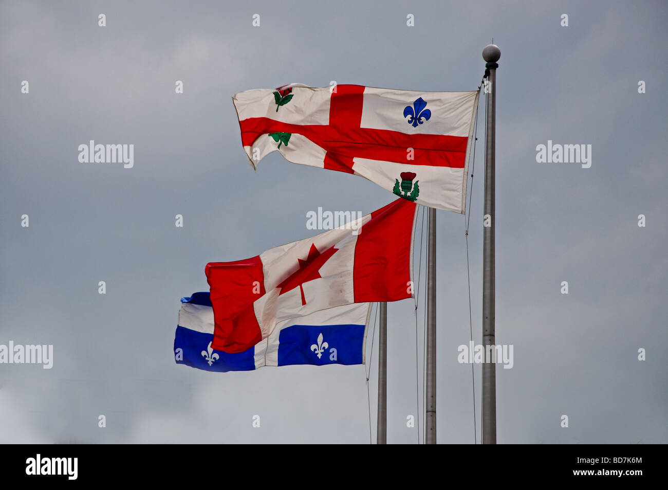 The Montreal, Canadian and Quebec flags flying in Old Montreal Stock Photo