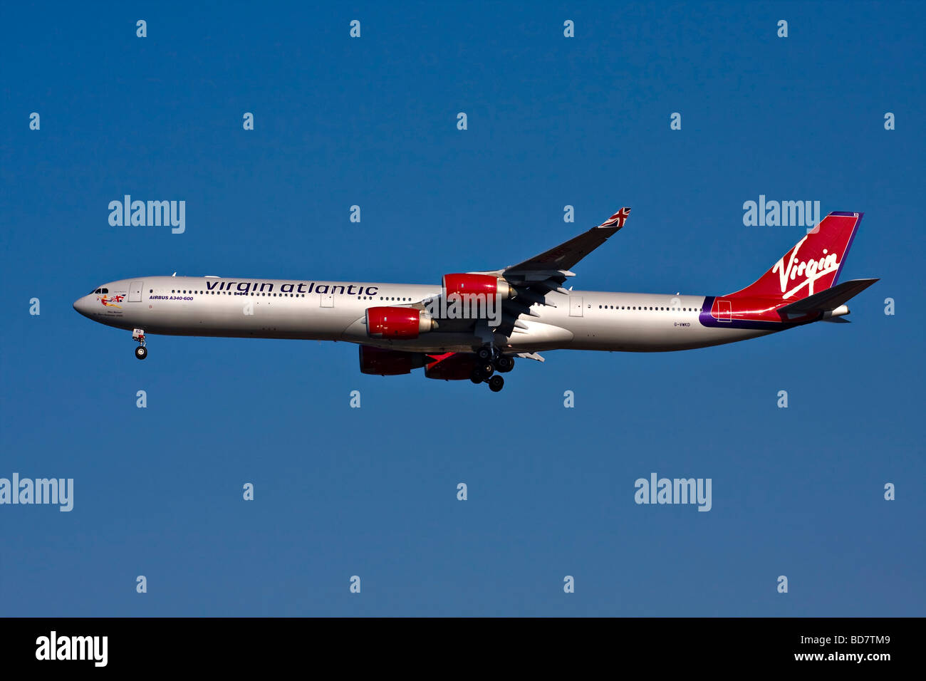 Virgin Atlantic Airbus A340-600 named 'Miss Behavin' with landing gear down. Stock Photo