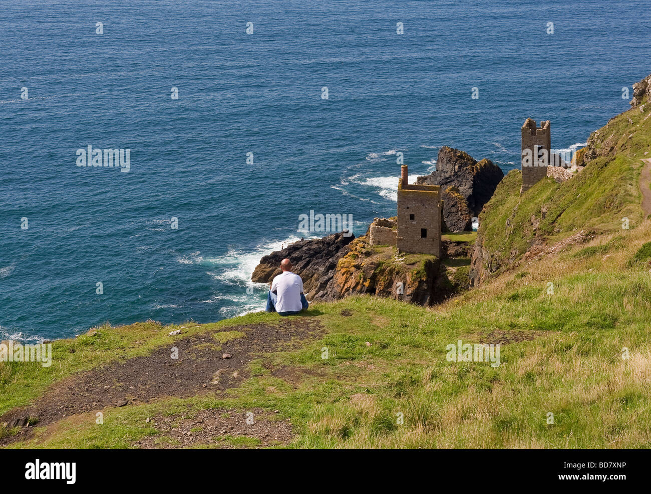 A man looking out over the Crowns engine houses at Botallack Tin Mining site in Cornwall.  Photo by Gordon Scammell Stock Photo