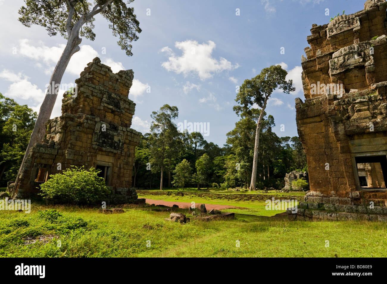 Heavily tilted and crumbling buildings around a dry pool near the Bayon temple Stock Photo