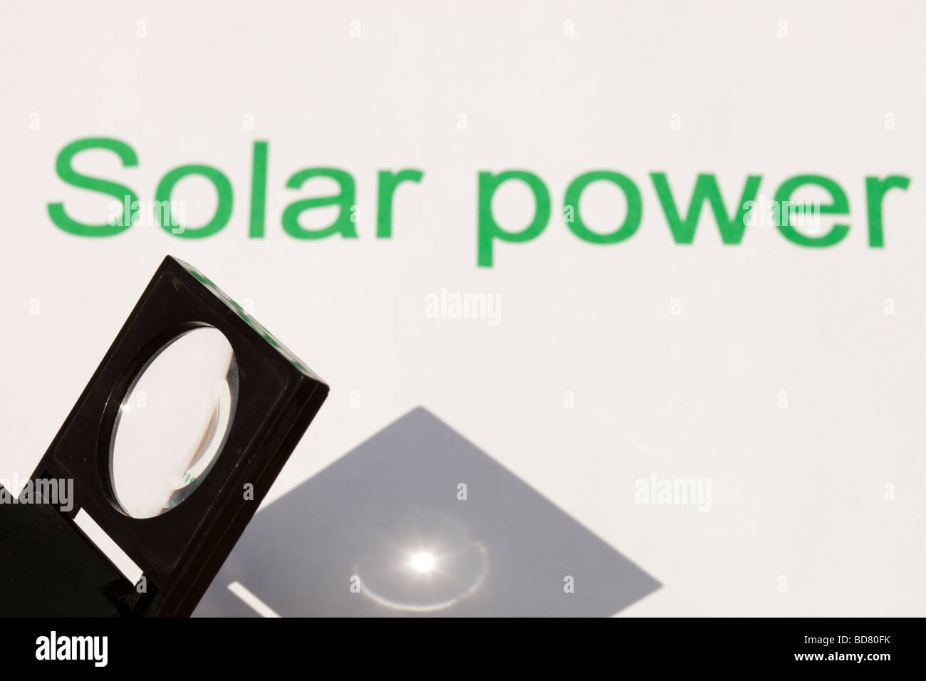 Solar power concentrating the suns power through a magnfying glass Stock Photo