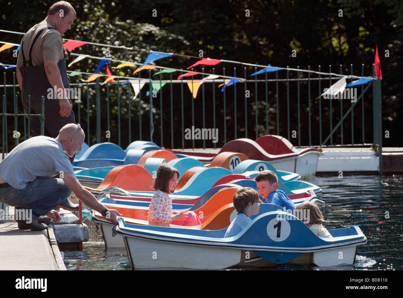 Children being launched into a lake on small paddle boats Stock Photo