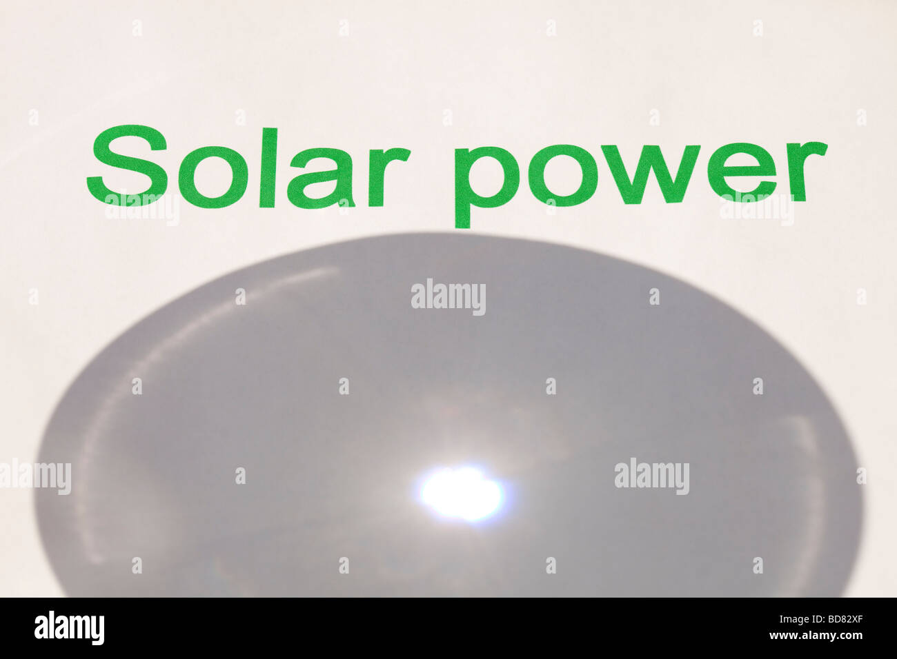 Solar power concentrating the suns power through a magnfying glass Stock Photo