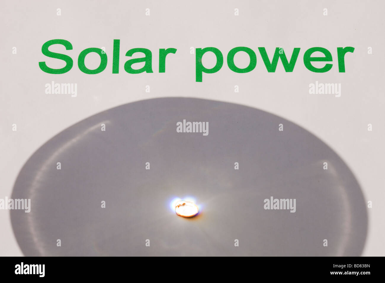 Solar power concentrating the suns power through a magnfying glass Stock Photo