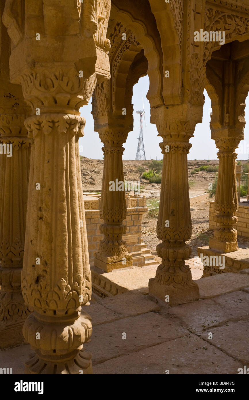 A wind turbine farm contrasts with the ancient carved memorials at Bada Bagh near Jaisalmer Stock Photo