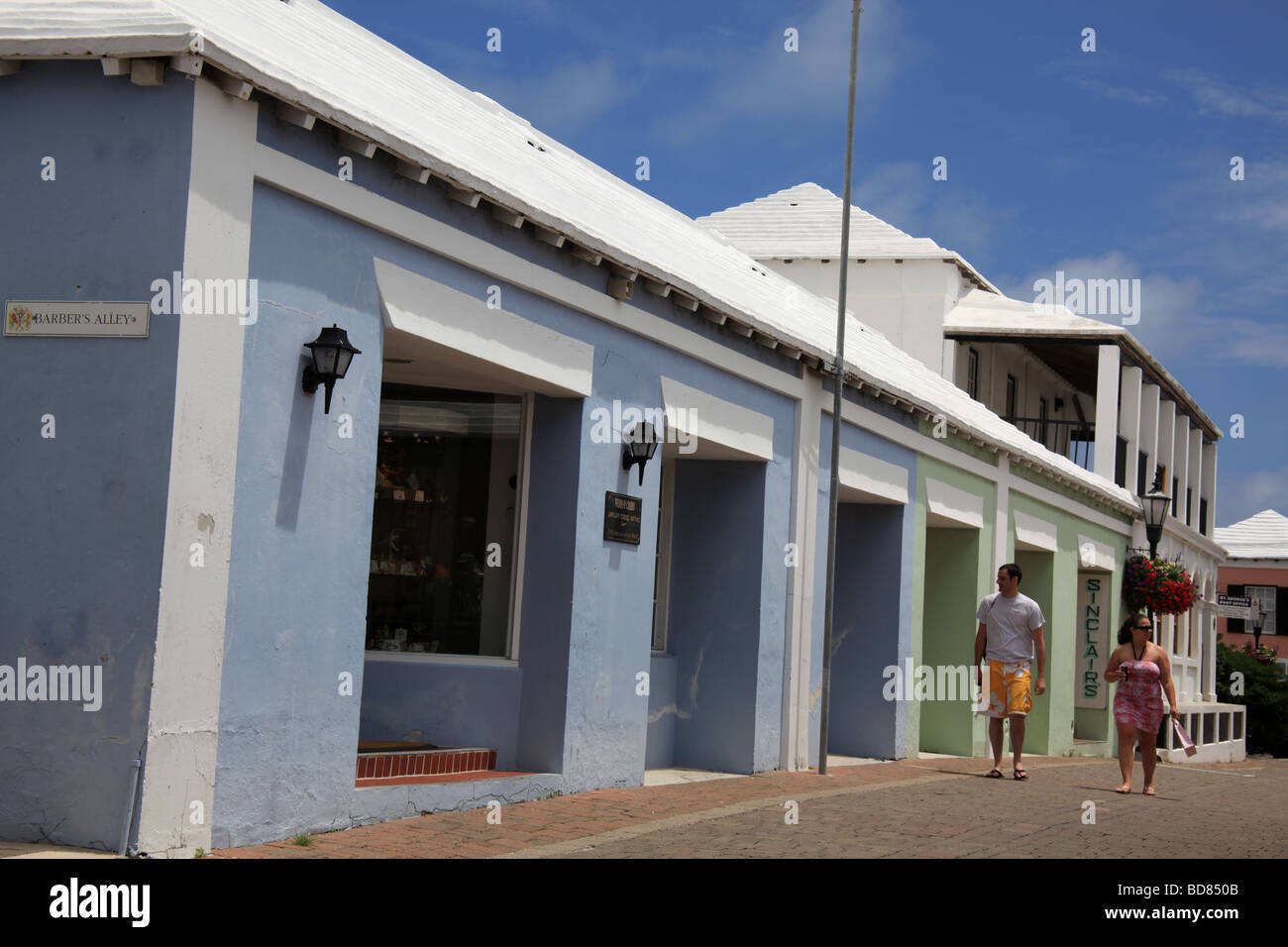 Tourists stroll past shops as they sightsee in St. Bermuda, a