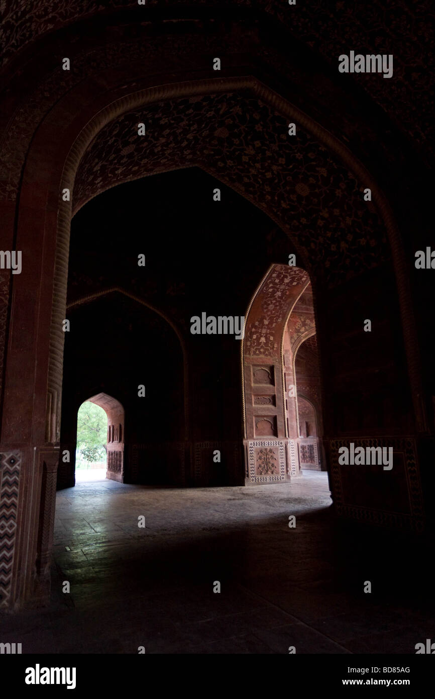 Deep shadow partly hides the delicate carvings and archways inside the red mosque next to the Taj Mahal Stock Photo