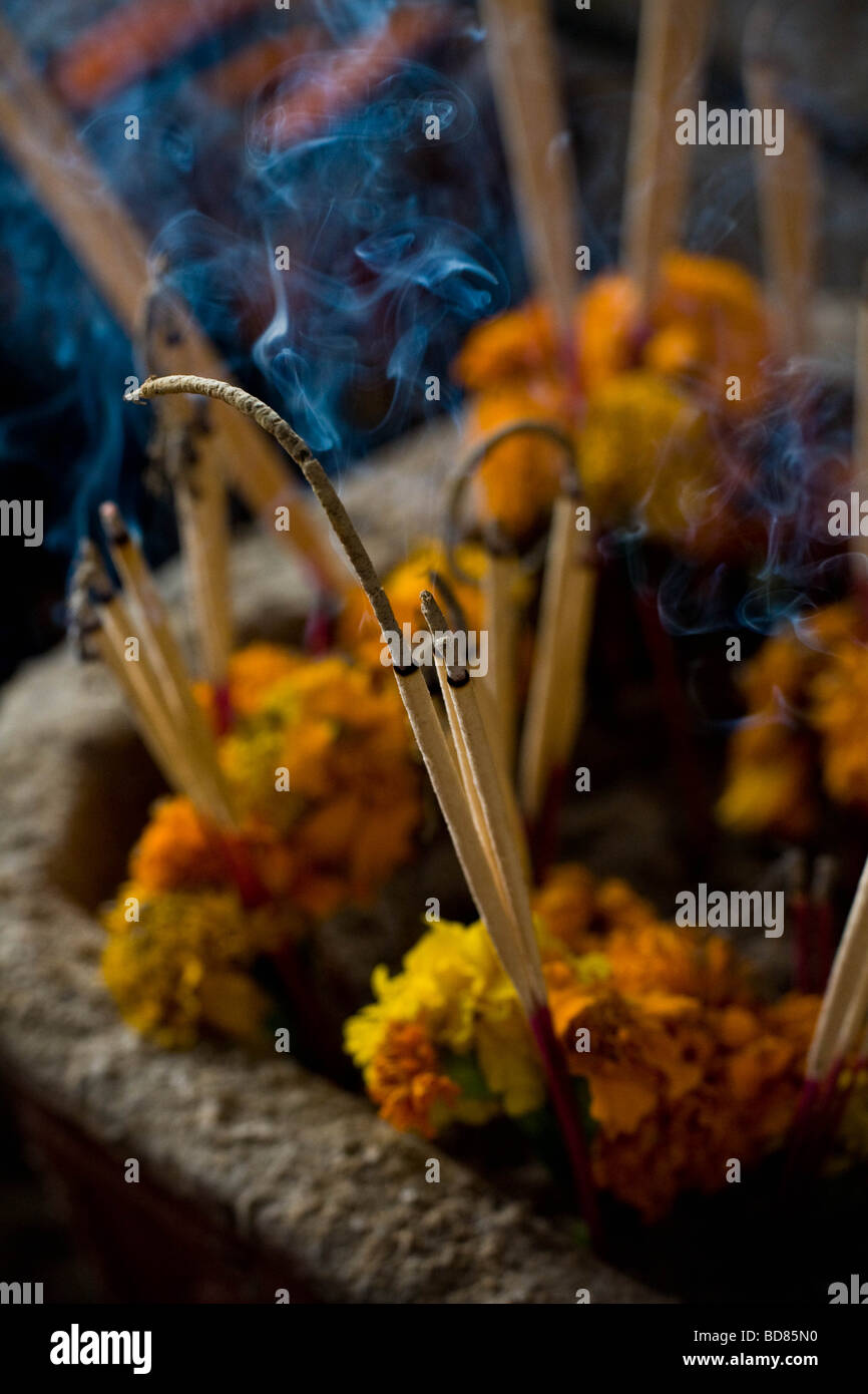 Burning incense in front of an altar in the Tham Phu Kham cave near Vang Vieng Laos Stock Photo
