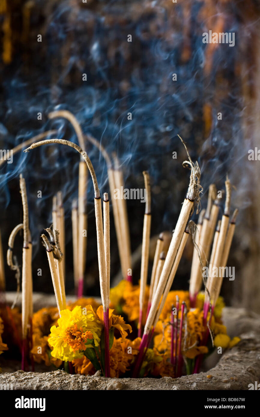 Burning incense in front of an altar in the Tham Phu Kham cave near