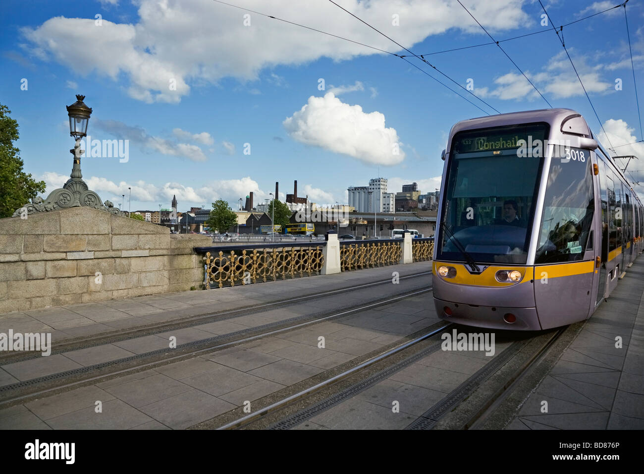 LUAS Tram on the Sean Heuston Bridge Over the River Liffey, With Guinness Brewery in Distance, Dublin City, Ireland Stock Photo