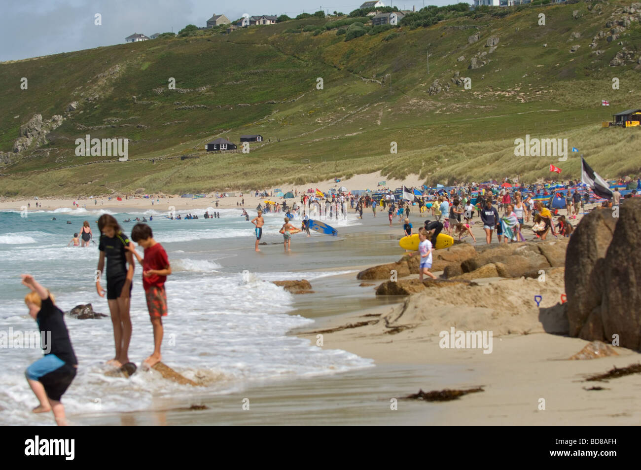 Crowd of bathers on Sennen Cove beach in Cornwall, UK Stock Photo