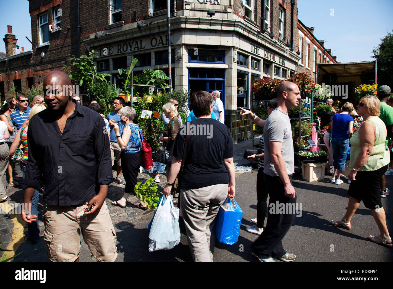 People gather at Columbia Road Flower Market in the East End of London. This market is as much social as it is about buying. Stock Photo