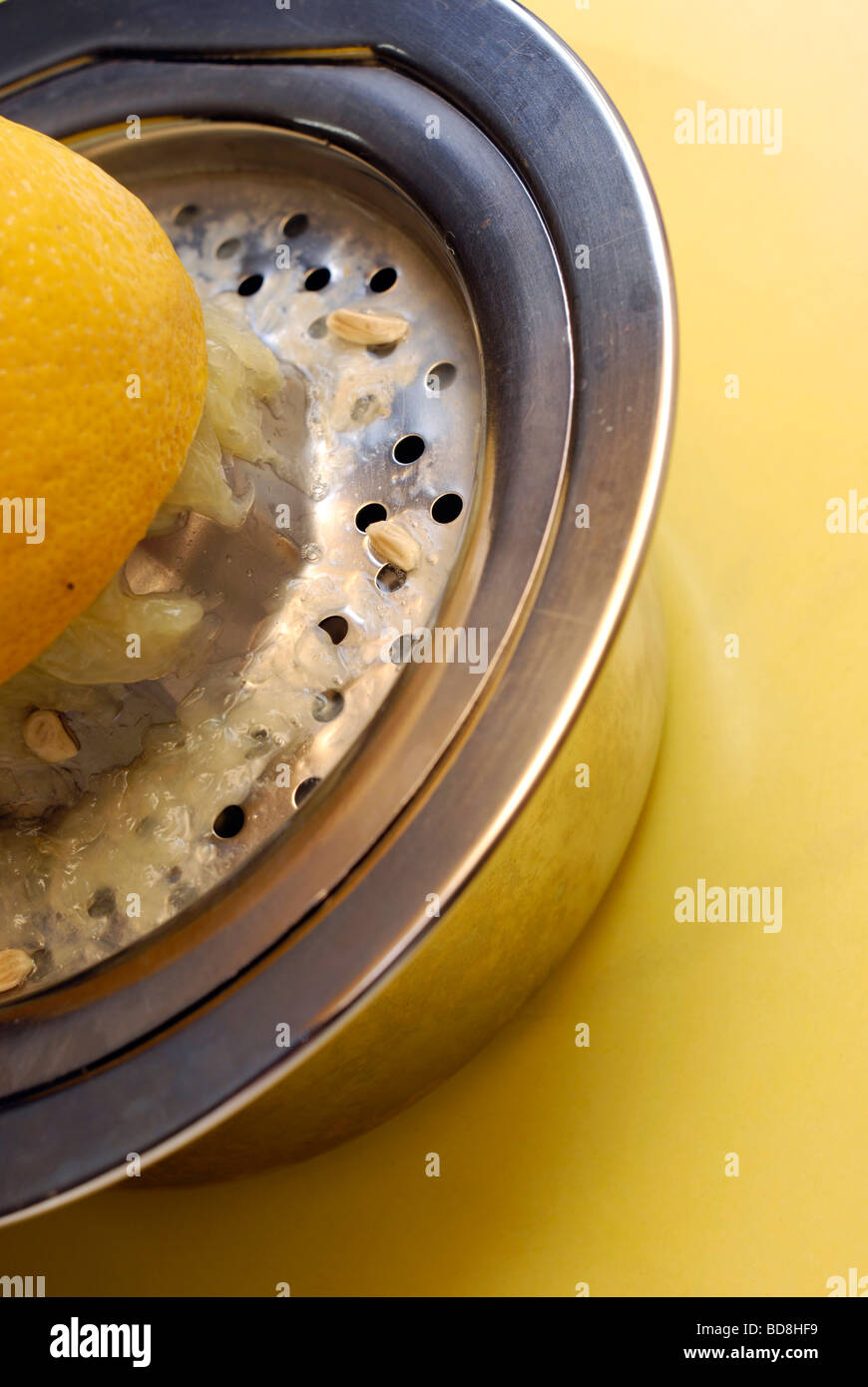 Lemon on metal juicer with juice squeezed out Stock Photo Alamy