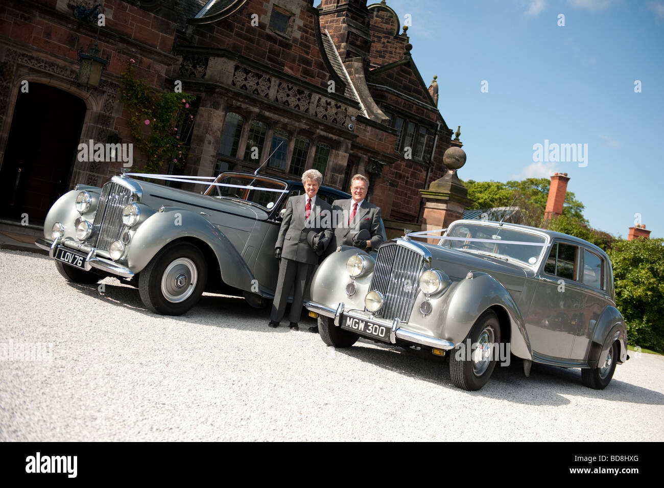 Two chauffeurs with old Bentleys outside large country house Stock Photo