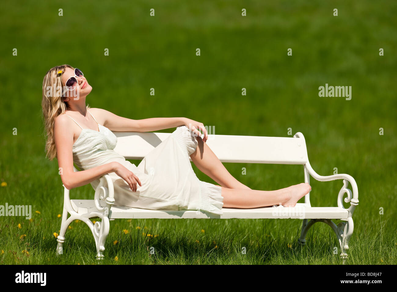 Beautiful woman sitting on white bench in park Stock Photo - Alamy