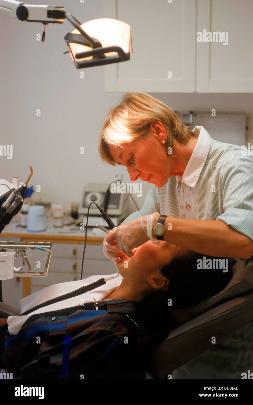 Woman dentist working on patient in dental office Stock Photo