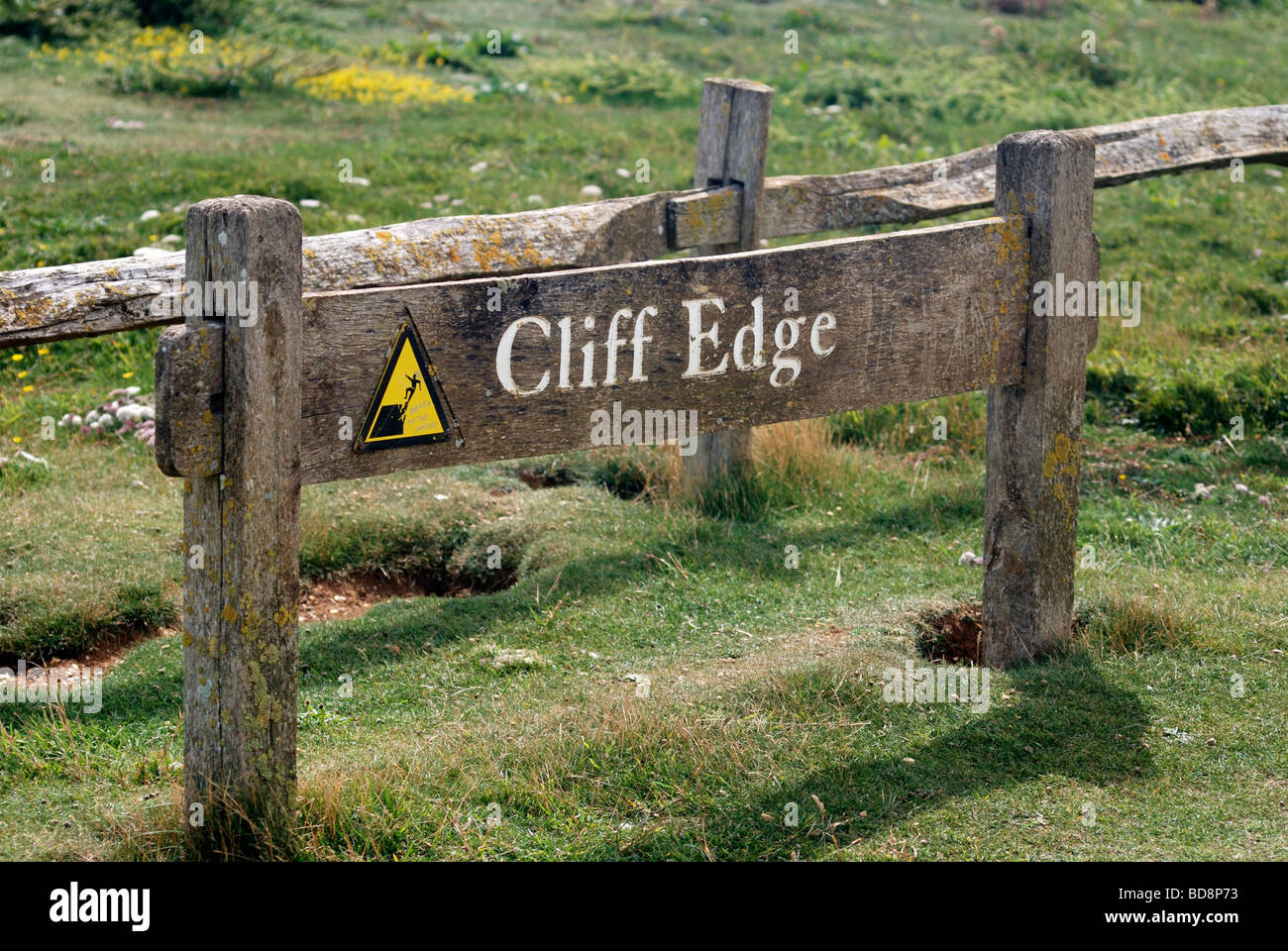 Sign warning people to keep away from a dangerous cliff edge Stock Photo